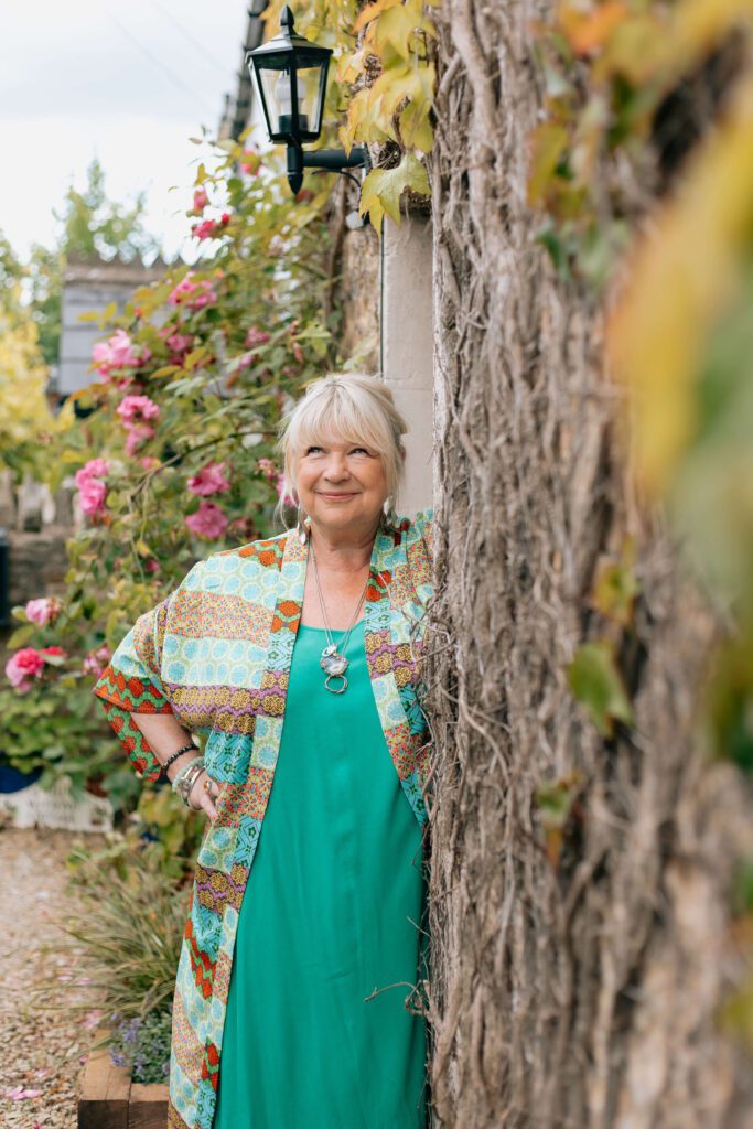 Therapist, Beverley Harper stands outside an English cottage.