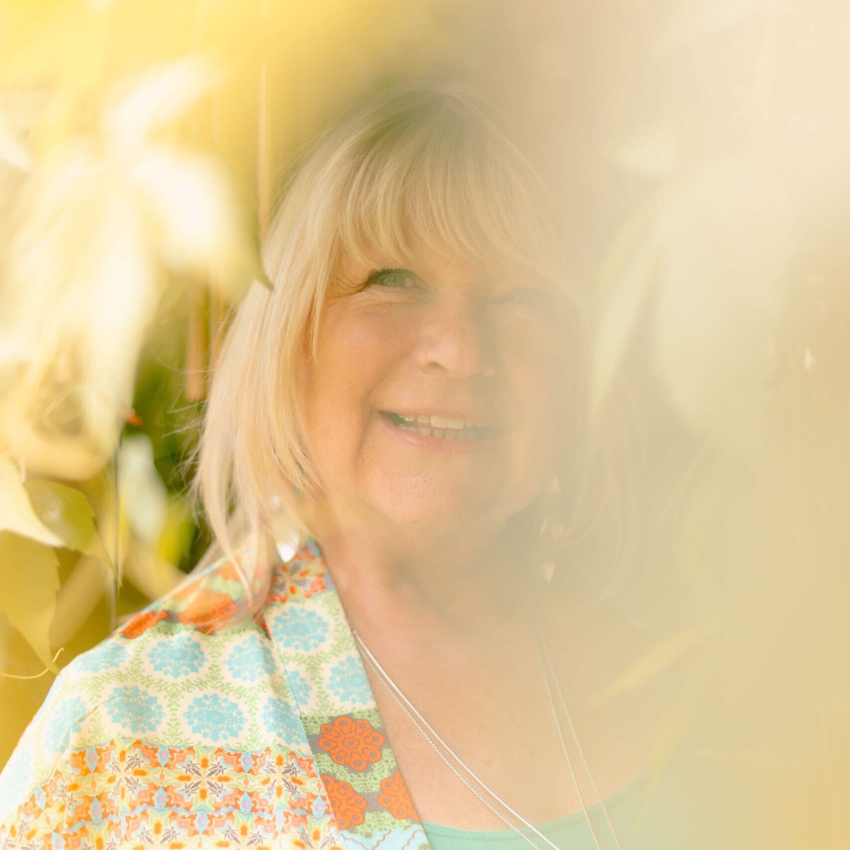Beverley Haper, psychologist photographed amonst foliage.