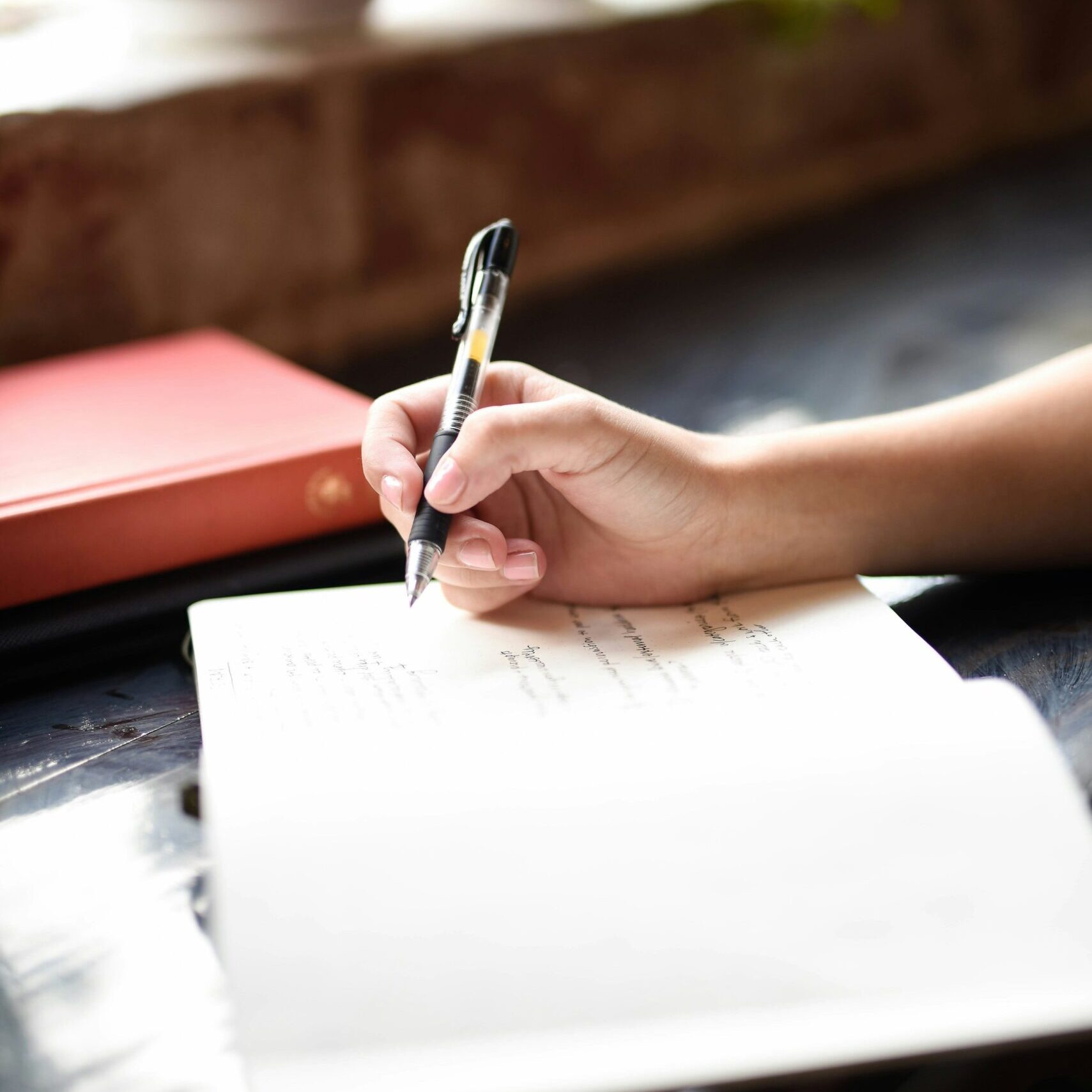 Daily journaling for mental health. Image shows someone's hand writing in a diary.